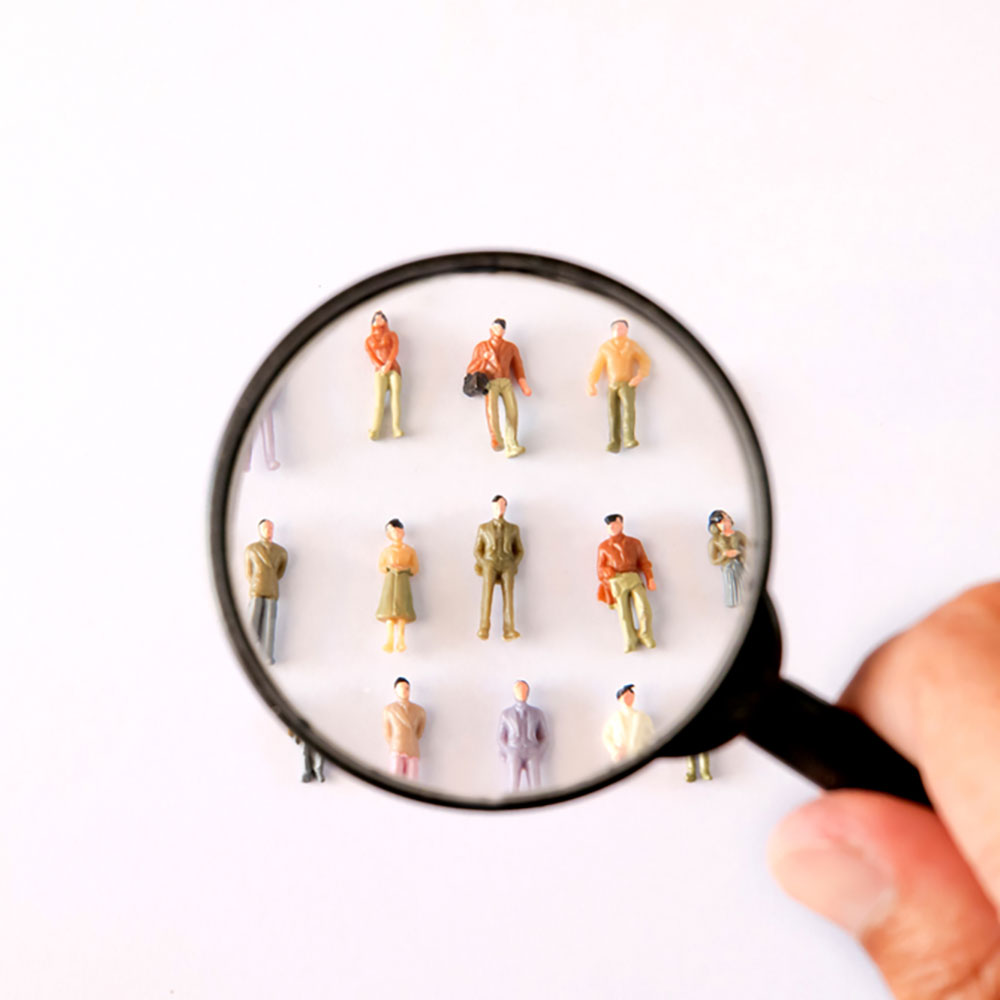 Magnifying glass over miniature figurines