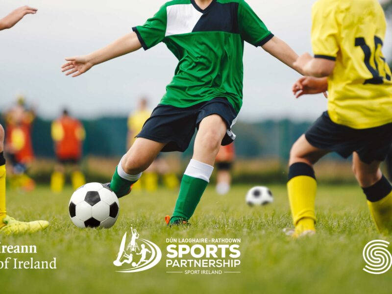 Lads playing football. Government logos at bottom.